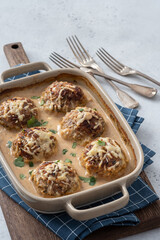 Baked meatballs with cabbage and rice with sour cream sauce