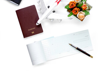 Mockup blank checkbook, passport, flowers and airplane isolated on blue wooden table background. Business trip and travel, Payment by cheque concept. Top view. Flat lay. 