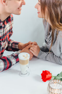 Lovely cropped shot of affectionale boy and girl, holding hands, ready to their first kiss.