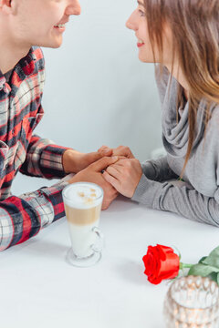 Lovely cropped shot of affectionale boy and girl, holding hands, ready to their first kiss.