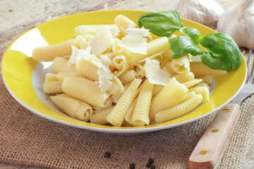 assiette de pâtes accompagnée de parmesan sur une table en bois