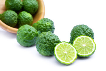 Bergamot fruit or kaffir lime fruits in wooden bowl pouring on white background. Herbs medicine plant concept.