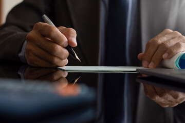 Business man hand writing and signing checkbook at office. Paycheck or payment by cheque concept.	