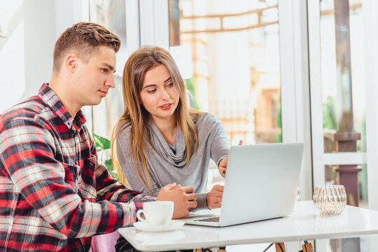 Two successful coleagues working on project in coffee shop.