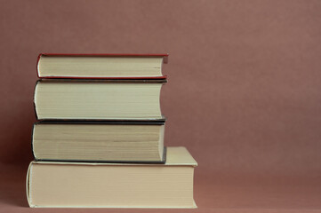 a stack of thick vintage books on a brown background