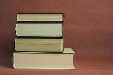 a stack of thick vintage books on a brown background