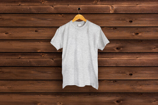 Heather gray T-shirt hung on the brown wood wall
