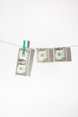 Money laundering - American dollars hanging on a string with pins