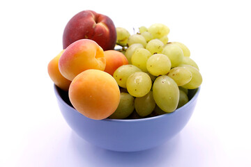 Grape bunch, peaches and apricot close-up on a white background