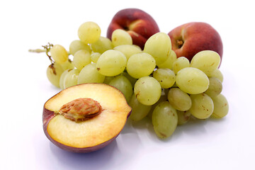 Bunch of grapes and peaches on a white background