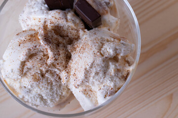 delicious creamy milky vanilla ice cream with caramel and chocolate addings in a glass container 