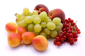 Grape bunch, peaches, red currants and apricot close-up on a white background