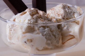 delicious creamy milky vanilla ice cream with caramel and chocolate addings in a glass container 