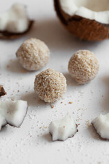 Конфеты из кокосовой стружки с шоколадом на светлом деревянном фоне. Натуральные сладости без сахора.