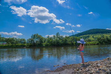 Little beautiful girl is fishing and rest outdoors. Summer vacation, healthy lifestyle, sport concept.