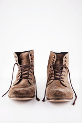 Brown worn vintage boots with untied laces in studio