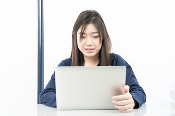 Young female student  sitting in living room and learning online