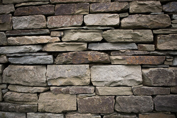 Hand built dry stone wall with different sized stones. Detail and texture.
