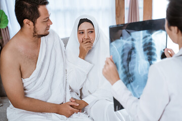 Fototapeta premium sad muslim woman and husband being cancel to travel for hajj