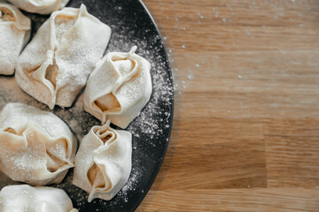 Stuffed homemade dumplings, manti of dough and minced on a dark plate