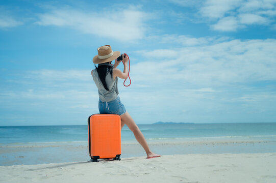 Woman tourist traveller standing on the sea beach ready going to the trip journey to explore the World