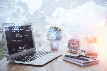 Computer on desktop with social network hologram. Double exposure. Concept of international people connections.