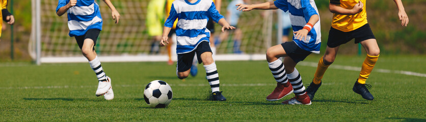 Horizontal Background of Running Soccer Players in Youth Teams. Kids Footballers in Duel on the Grass Field. Boys in Soccer Uniforms and Soccer Cleats
