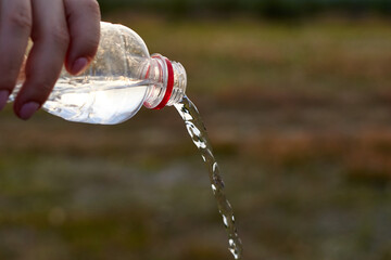 Pure clear water is poured from a plastic bottle.