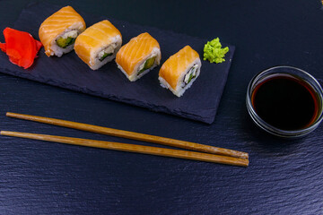 Sushi rolls Philadelphia on a black slate