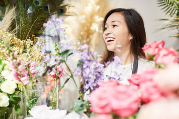 Floristin mit Auswahl an Blumen im Blumenladen