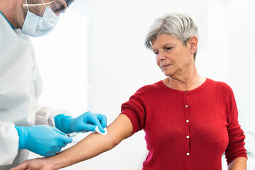 Obraz premium Doctor doing medical injection syringe vaccine to senior patient in hospital for preventing and stop corona virus outbreak - Healthcare medicine and cure against pandemic concept