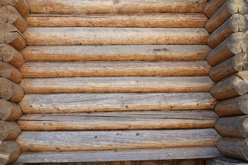 A wall made of natural wood of different sizes and shapes, Log house or barn, textured horizontal walls