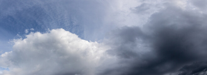 A wide panorama of the sky with impending thunderstorms and rain clouds in a village in the...