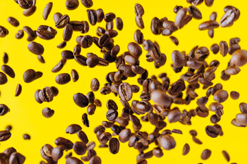 Fototapeta na wymiar Flying coffee beans on a bright yellow background