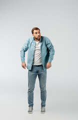 young man posing like puppet isolated on grey