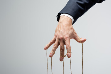 cropped view of puppeteer with strings on fingers isolated on grey