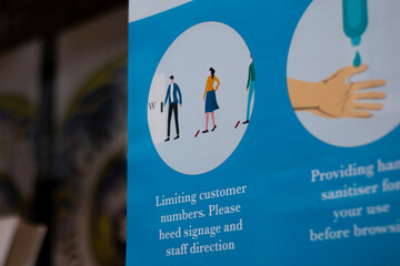 COVID 19 health and safety social distancing information sign for shoppers in retail store window