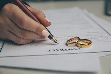 Woman signing marriage contract, closeup.