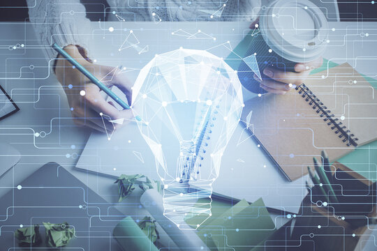 Drawing bulb over woman's hands taking notes background. Concept of idea. Double exposure