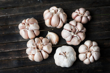 Several heads of garlic taken from the top, showing wood grain