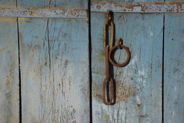 The old door of the village house on which the iron ring is mounted