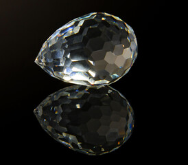Large faceted crystal on a black reflective surface