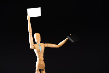 wooden marionette in tie with suitcase holding blank placard isolated on black