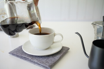 Hand poured water of coffee  on cup with equipment, tool brewing on bar at kitchen home