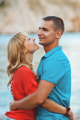 Fototapeta premium The happy young couple walking on a wooden pier on the seashore and are dressed in fashionable clothes. Having fun.