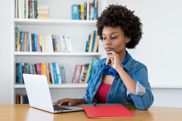 Working african american young adult woman at computer