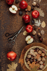 Autumn still life with red apples and nuts on an old iron background. The view from the top.