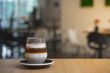 Ice coffee plated on a table in a modern Europe cafe. Background blurred, space for copy text