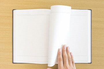 ノートのページをめくっている男の手