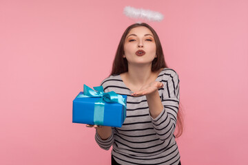 Portrait of beautiful angelic girl with saint halo over head holding gift for Valentine's day and...